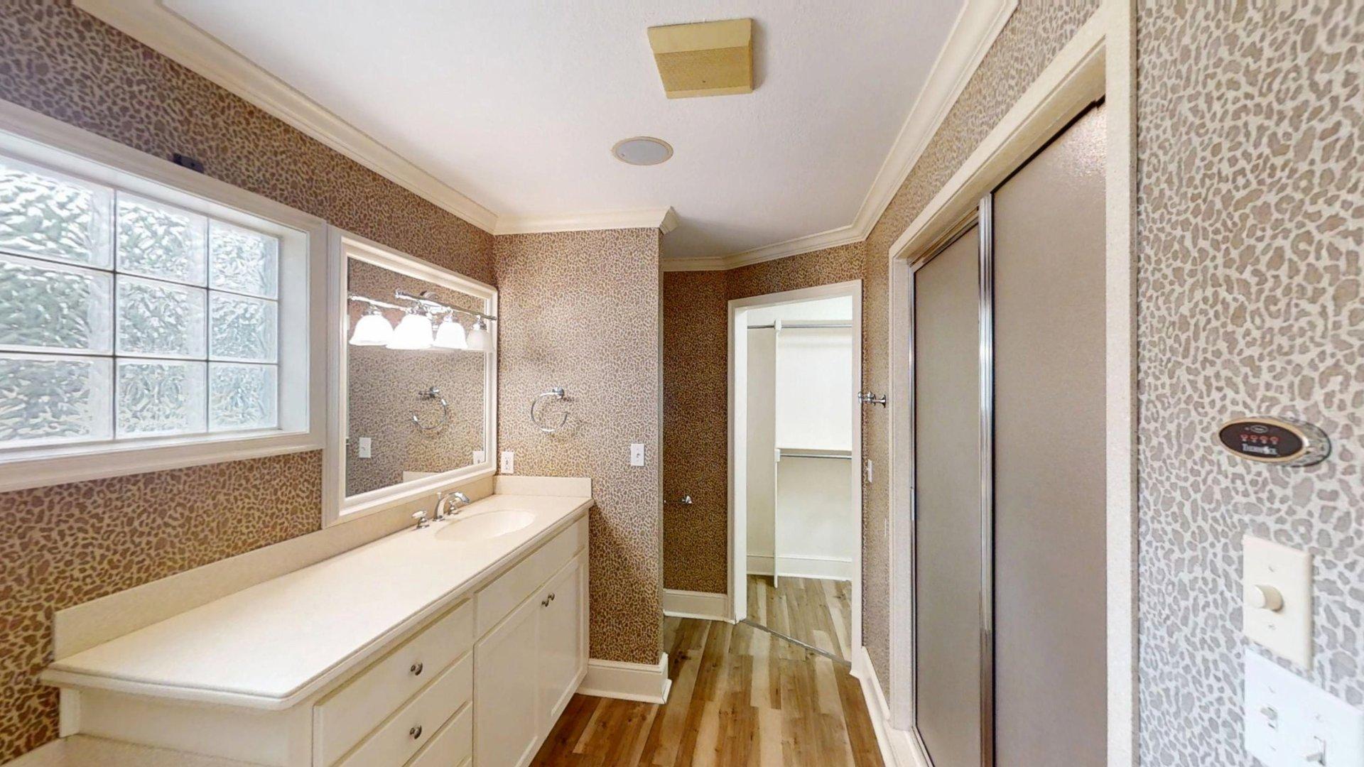 219 F Street Southwest Ardmore, OK 73401 - Photo 42 of 58 Elongated vanity with integrated sink, rectangular mirror, and glass block window