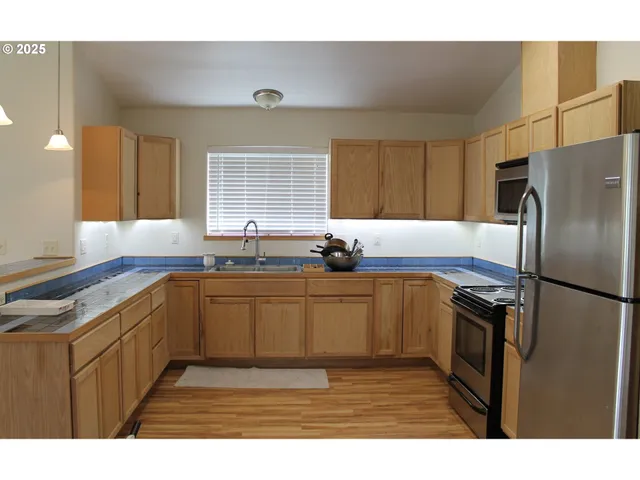 a kitchen with stainless steel appliances granite countertop a refrigerator and a sink
