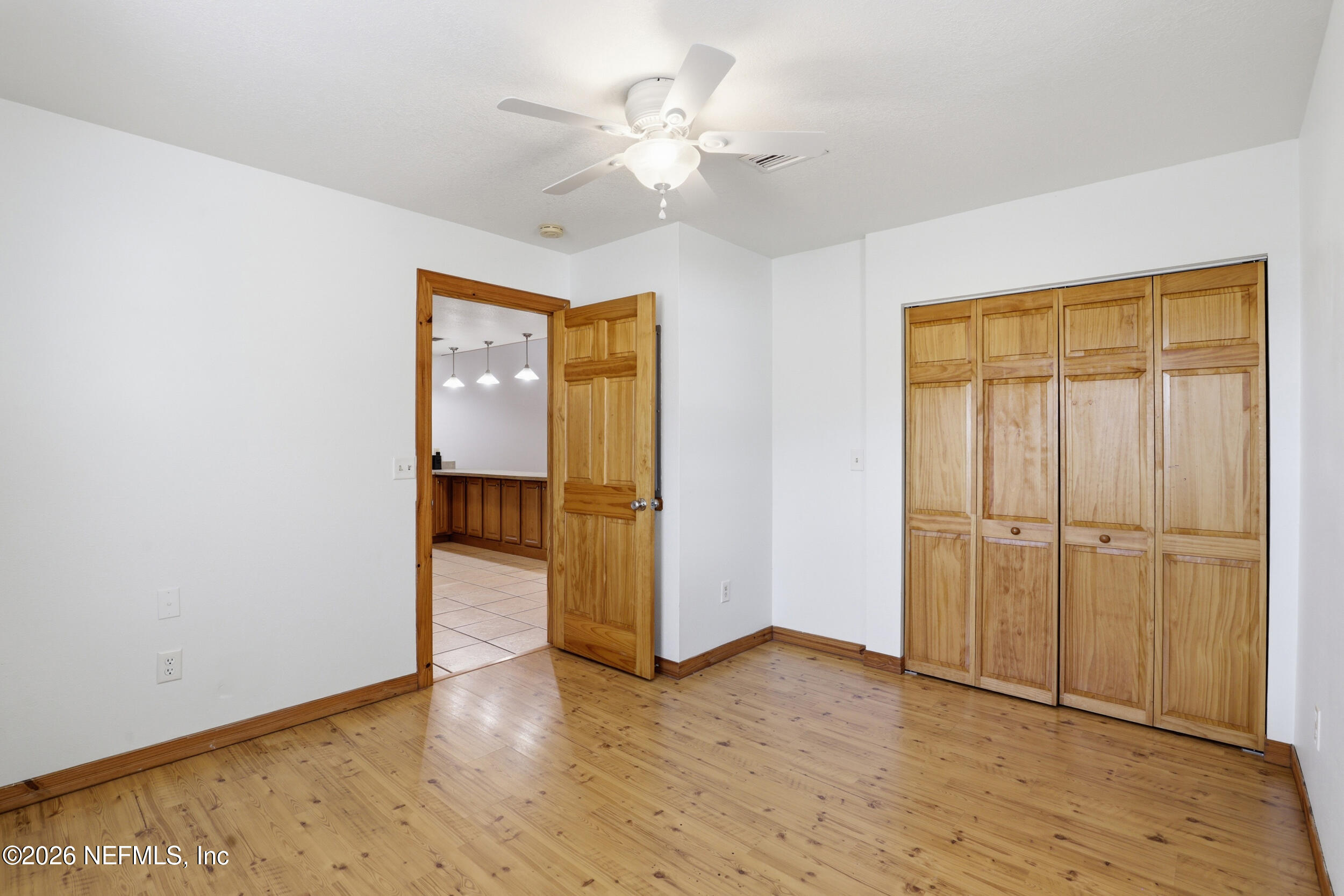 5714 Southeast 4th Avenue Keystone Heights, FL 32656 - Photo 17 of 53 an empty room with wooden floor and a ceiling fan