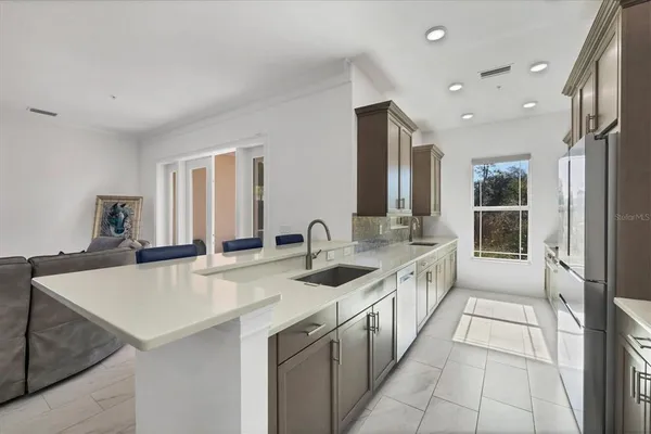 a kitchen with stainless steel appliances granite countertop a sink and a refrigerator