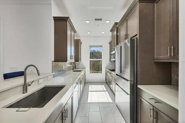 a kitchen with stainless steel appliances granite countertop a refrigerator and a sink