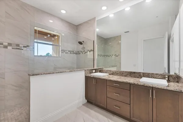 a bathroom with a granite countertop sink toilet and shower