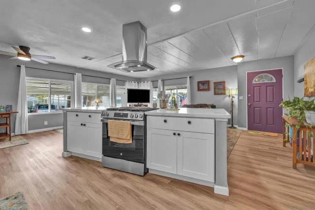 a kitchen with stainless steel appliances granite countertop a stove top oven a sink dishwasher and cabinets with wooden floor