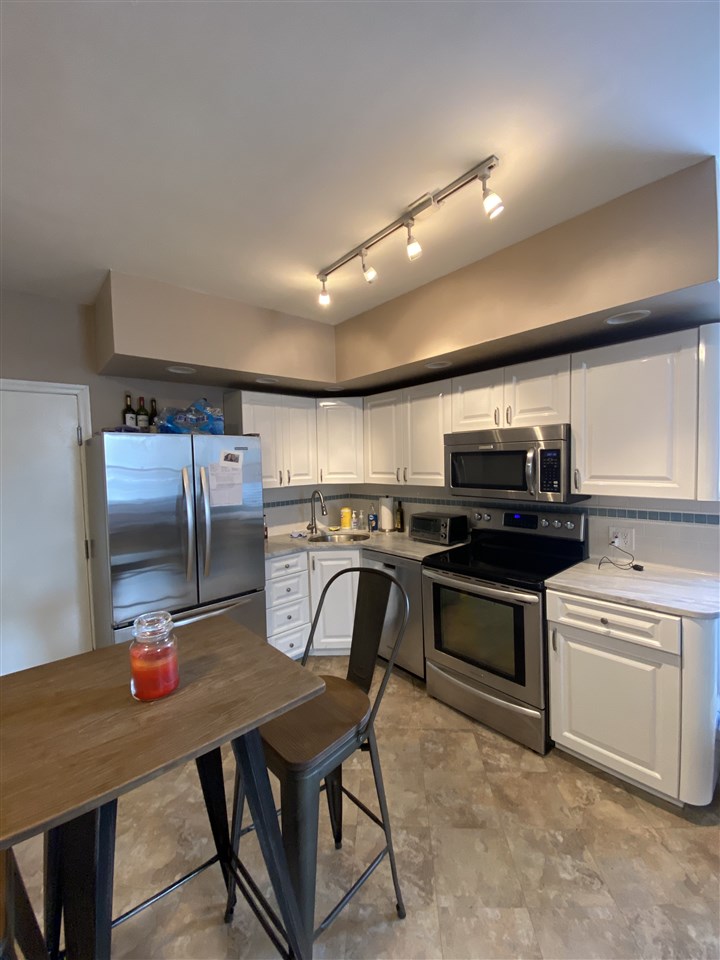333 Monroe Street, Unit 1A Hoboken, NJ 07030 - Photo 4 of 15 a kitchen with stainless steel appliances a table chairs and a refrigerator