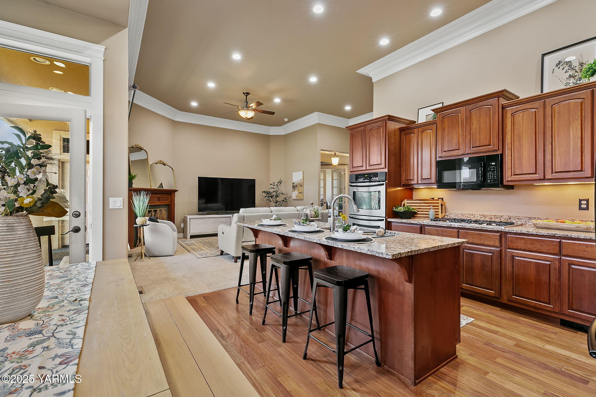 609 North 74th Avenue Yakima, WA 98908 - Photo 19 of 34 a open dining room with stainless steel appliances granite countertop a sink dishwasher a stove a refrigerator with a dining table and chairs with wooden floor