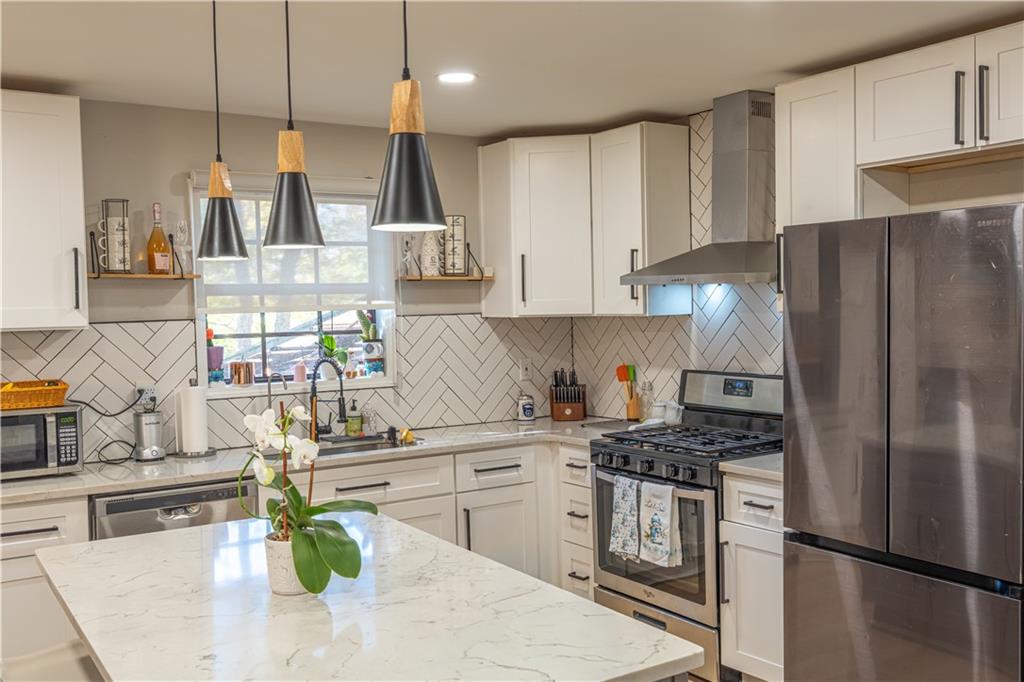 3316 Alcazar Drive Southwest Lilburn, GA 30047 - Photo 11 of 37 a kitchen with stainless steel appliances granite countertop a sink a stove a refrigerator a center island and cabinets