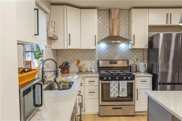 a kitchen with stainless steel appliances granite countertop a stove and a refrigerator