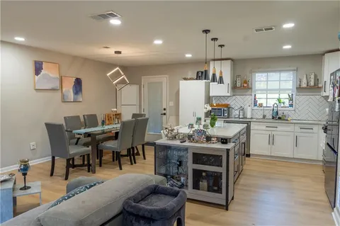 a kitchen with a table chairs appliances and cabinets