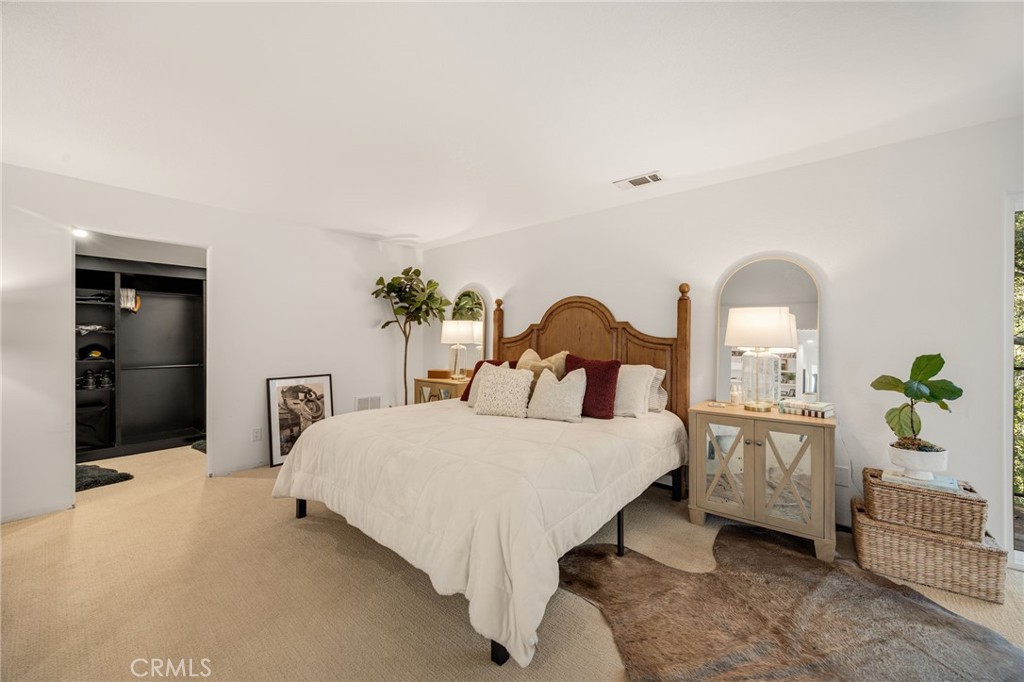 48980 De Luz Road Temecula, CA 92590 - Photo 31 of 50 a bedroom with a bed table flowerpot and window