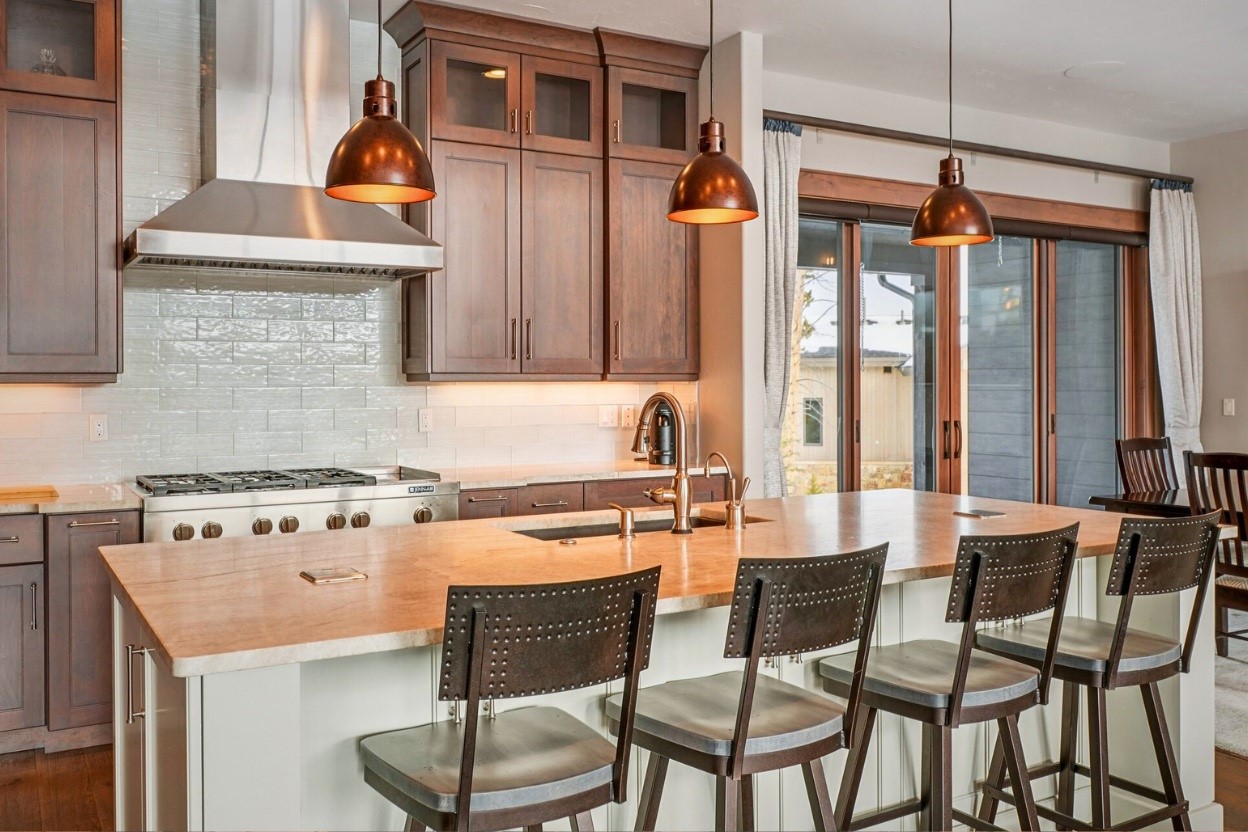 60 Barton Ridge Drive Breckenridge, CO 80424 - Photo 13 of 50 a kitchen with stainless steel appliances granite countertop a stove top oven a dining table and chairs with wooden floor