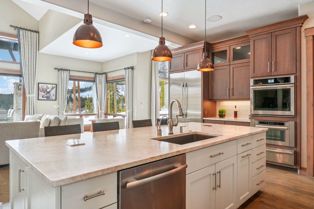 60 Barton Ridge Drive Breckenridge, CO 80424 - Photo 14 of 50 Kitchen with white cabinets, appliances with stainless steel finishes, dark wood-style floors, decorative light fixtures, and tasteful backsplash