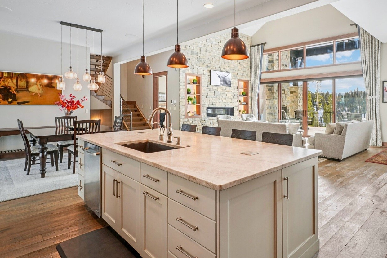 60 Barton Ridge Drive Breckenridge, CO 80424 - Photo 15 of 50 Kitchen with light stone countertops, open floor plan, decorative light fixtures, dark wood finished floors, and a center island with sink