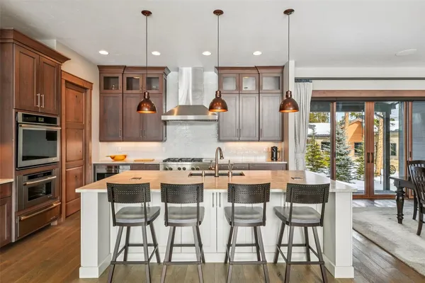a kitchen with a table chairs and a wooden floor