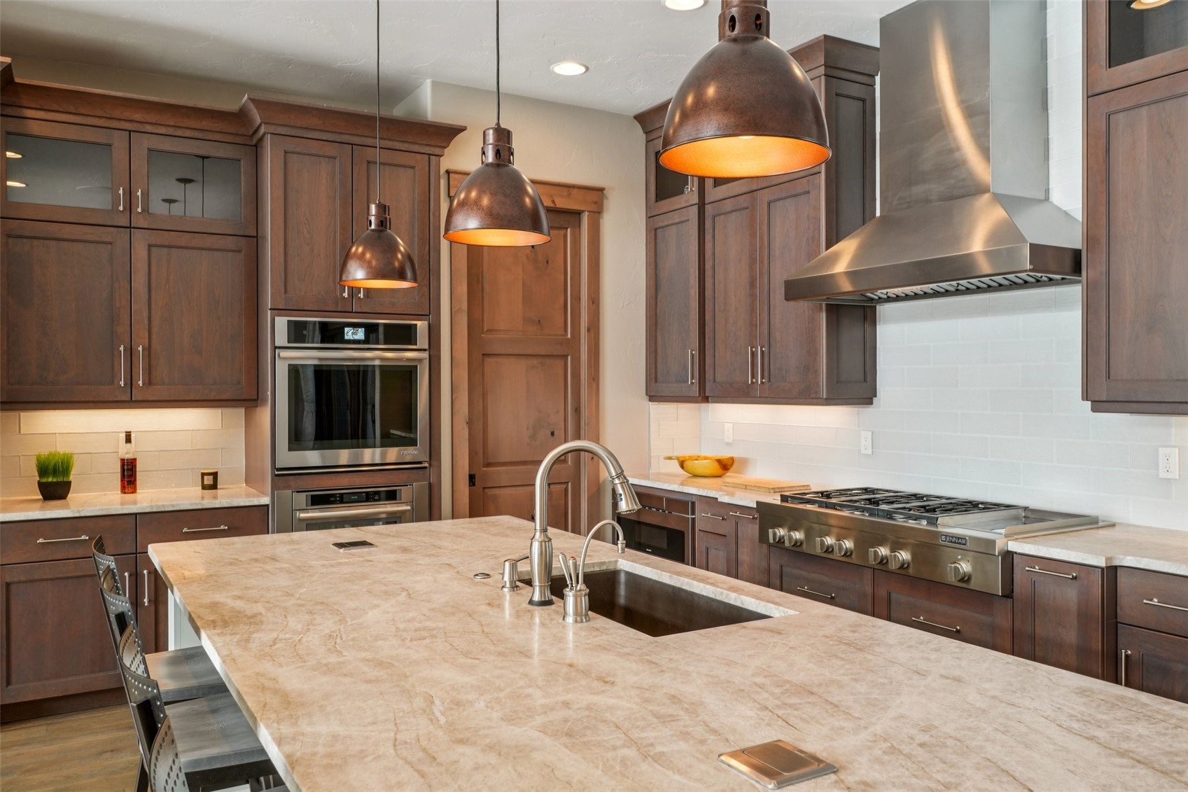 60 Barton Ridge Drive Breckenridge, CO 80424 - Photo 18 of 50 Kitchen featuring glass fronted cabinets, tasteful backsplash, light stone counters, stainless steel appliances, and decorative light fixtures