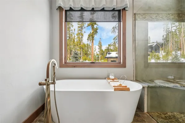 a bathroom with a granite countertop sink a mirror and shower