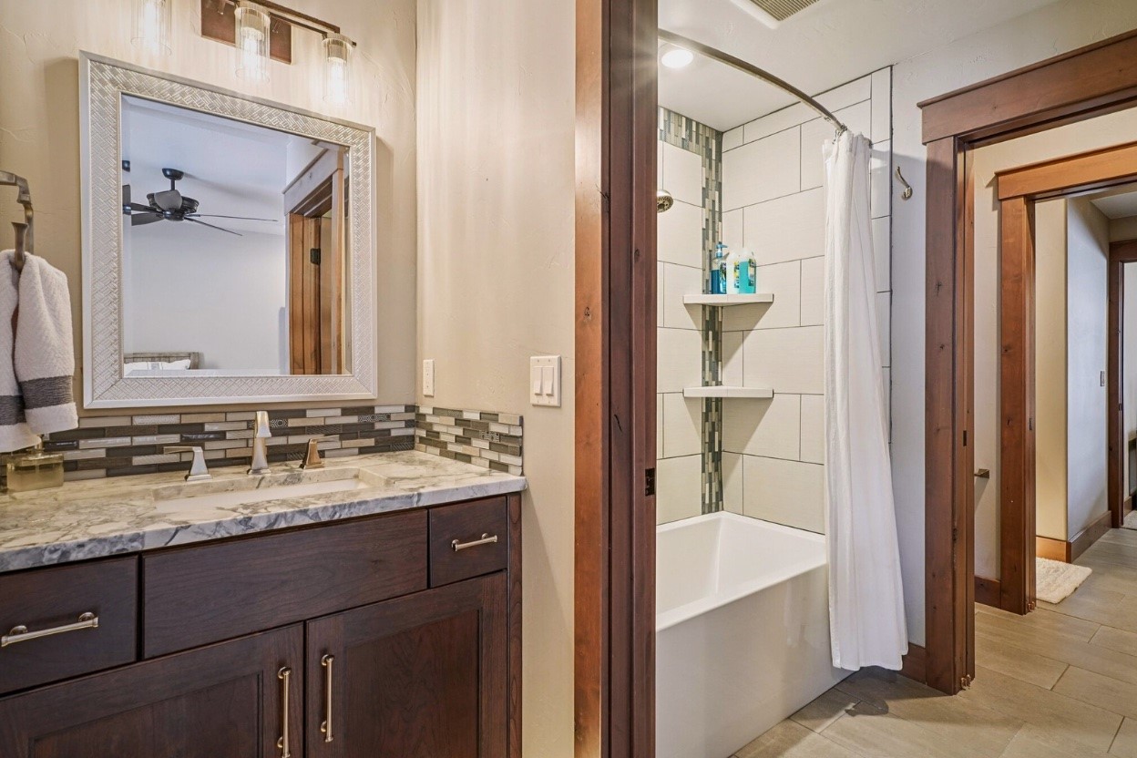 60 Barton Ridge Drive Breckenridge, CO 80424 - Photo 30 of 50 a bathroom with a granite countertop sink mirror and a bathtub
