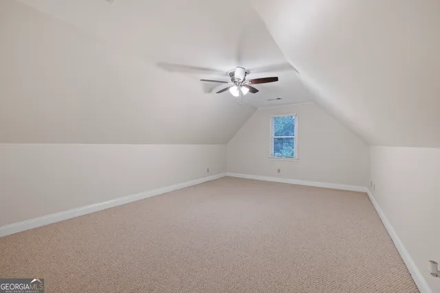 an empty room with a fan & a ceiling fan