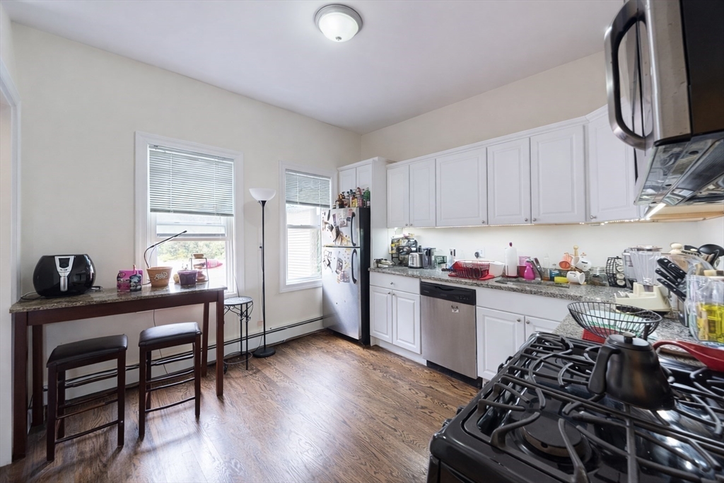 11 Seckel Street, Unit 1 Cambridge, MA 02141 - Photo 2 of 21 a kitchen with granite countertop a stove and a refrigerator