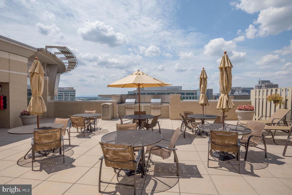 11800 Sunset Hills Road, Unit 514 Reston, VA 20190 - Photo 14 of 57 a group of chairs sitting in patio with a table under an umbrella