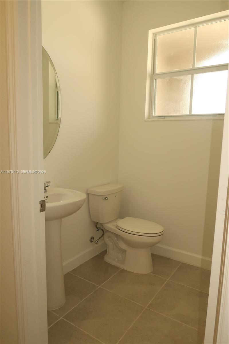 1509 Southeast 27th Street Homestead, FL 33035 - Photo 17 of 27 a bathroom with a toilet a sink a shower and a window
