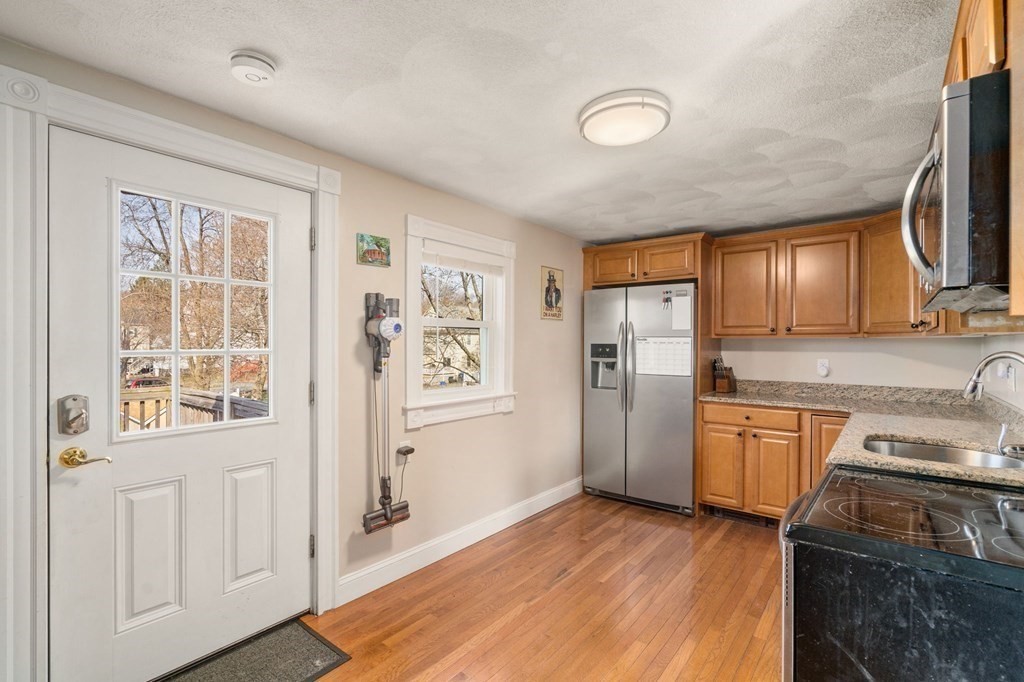 83 Cedar Street Wakefield, MA 01880 - Photo 4 of 36 a kitchen with stainless steel appliances granite countertop a refrigerator a stove top oven a sink and dishwasher