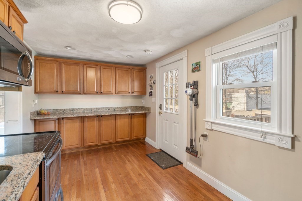 83 Cedar Street Wakefield, MA 01880 - Photo 6 of 36 a kitchen with stainless steel appliances granite countertop a stove a sink dishwasher and a microwave oven with wooden floor