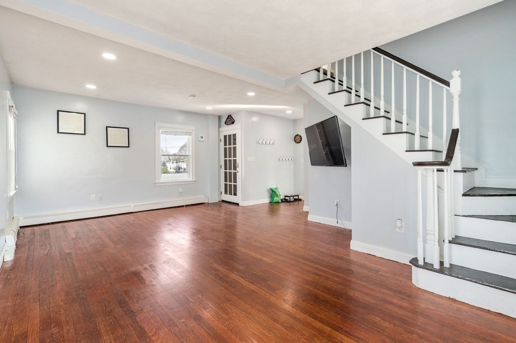 83 Cedar Street Wakefield, MA 01880 - Photo 8 of 36 a view of an empty room with wooden floor and stairs