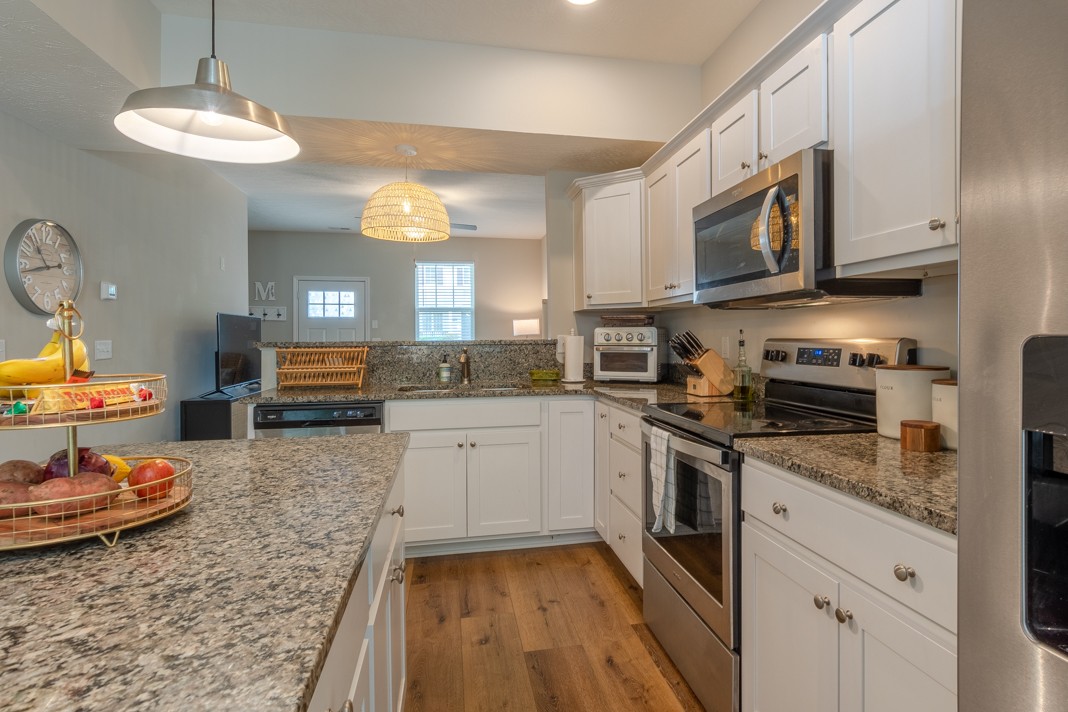 1382 Rural Hill Road, Unit 316 Antioch, TN 37013 - Photo 10 of 23 a kitchen with stainless steel appliances granite countertop a stove a sink dishwasher and a microwave oven with white cabinets