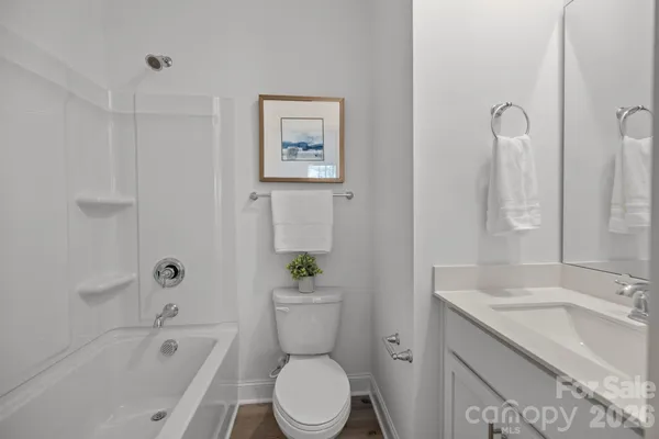 a bathroom with a granite countertop toilet a sink and bathtub