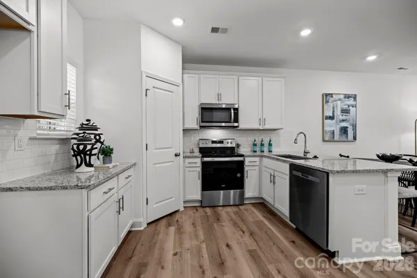 a kitchen with granite countertop a sink stove and refrigerator