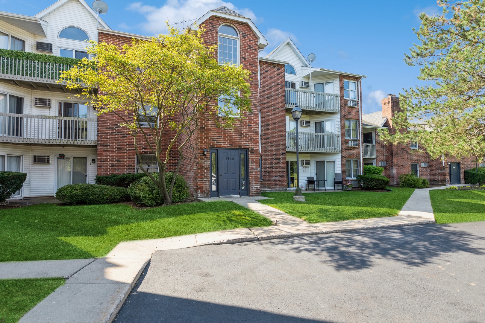a front view of a residential houses with yard and green space