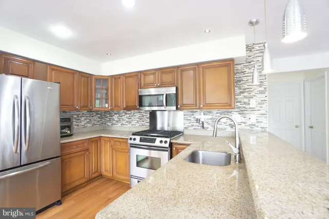a kitchen with a refrigerator sink and wooden cabinets