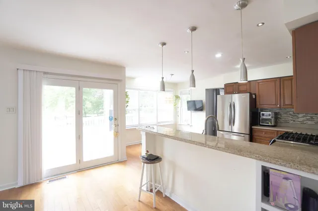 a kitchen with stainless steel appliances granite countertop a sink and a refrigerator