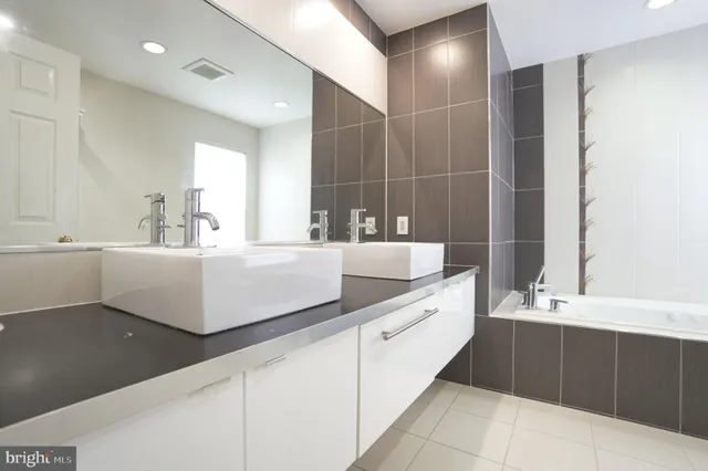 a bathroom with a double vanity sink toilet mirror and shower