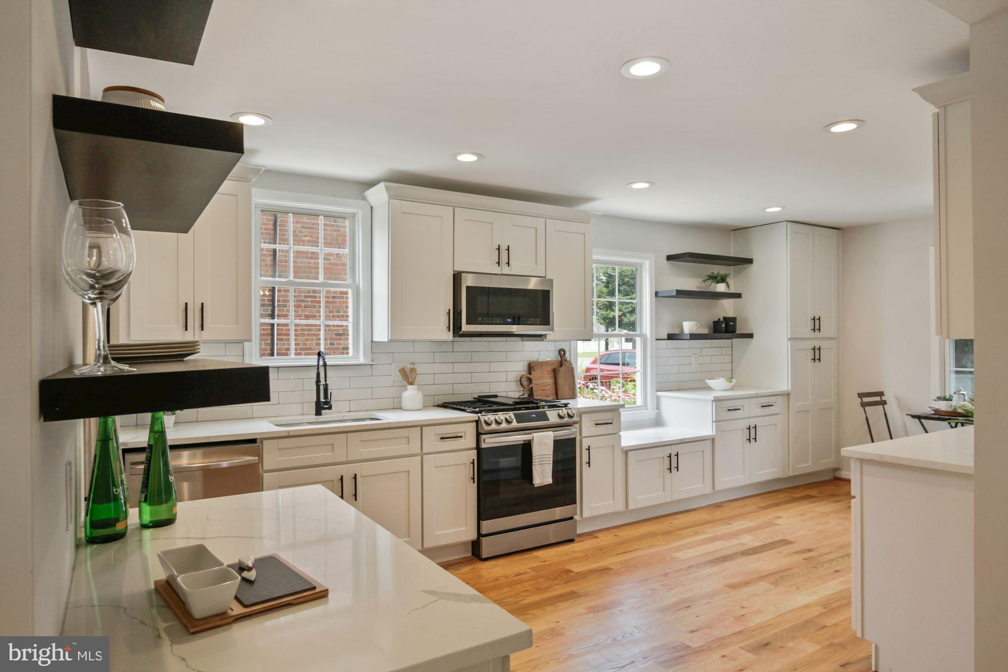 8112 Old Georgetown Road Bethesda, MD 20814 - Photo 15 of 51 a kitchen with stainless steel appliances granite countertop a stove top oven a sink dishwasher and white cabinets with wooden floor