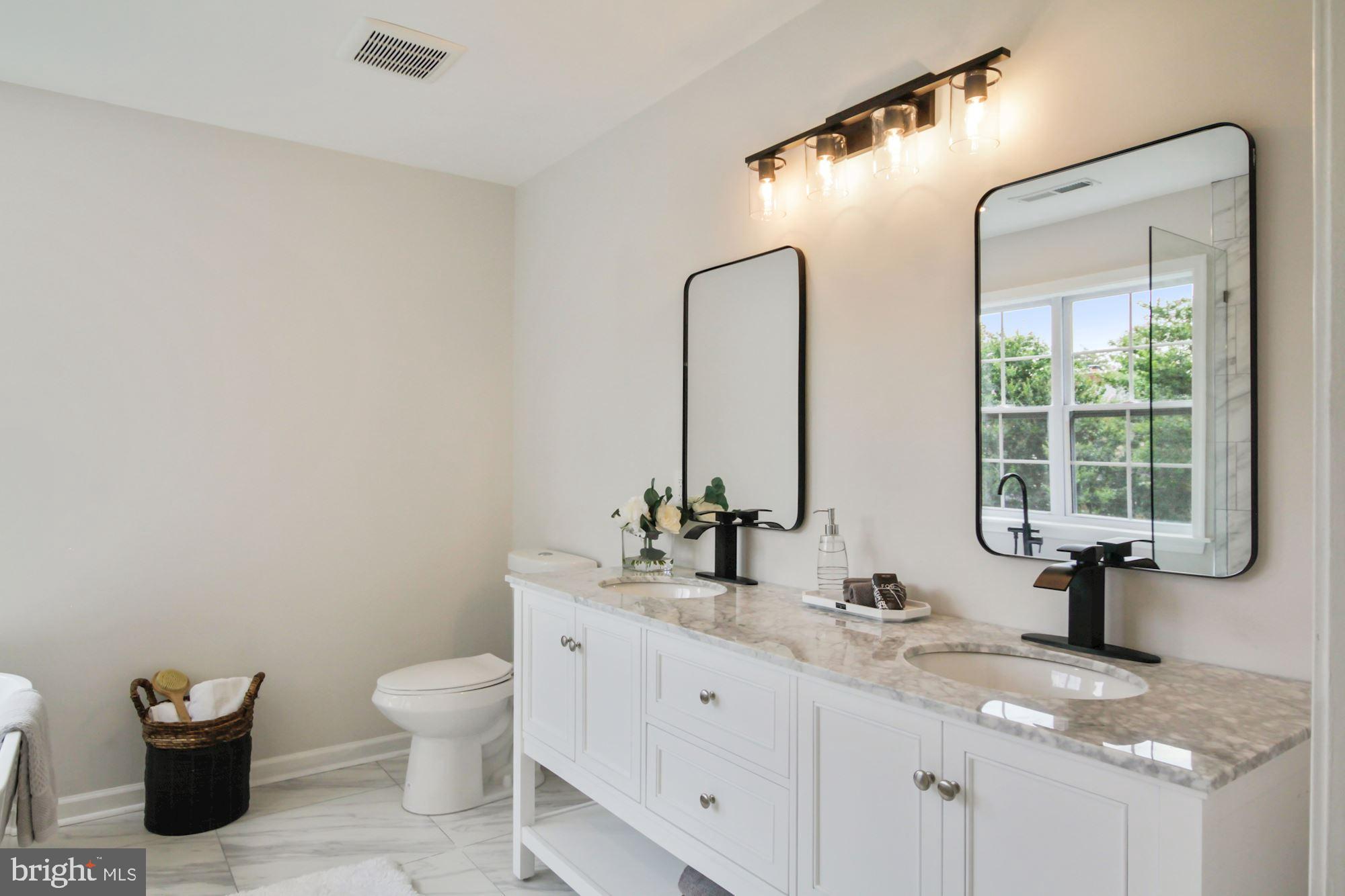 8112 Old Georgetown Road Bethesda, MD 20814 - Photo 24 of 51 a bathroom with a granite countertop sink a toilet and mirror