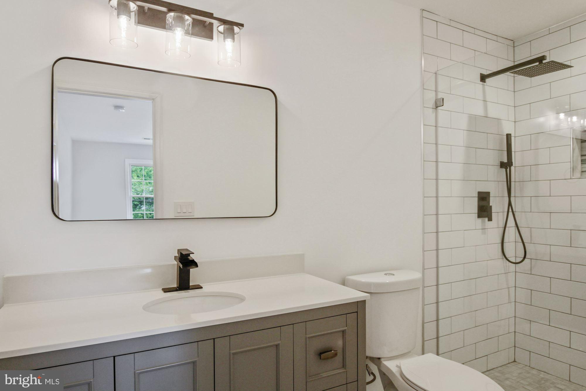 8112 Old Georgetown Road Bethesda, MD 20814 - Photo 30 of 51 a bathroom with a toilet sink vanity and mirror