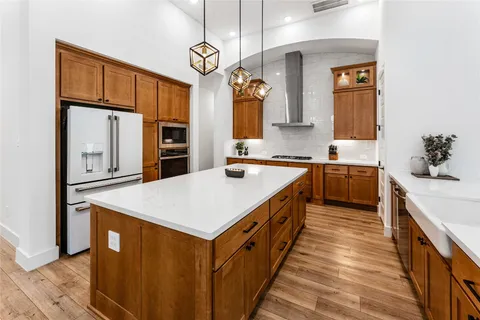 a backyard of a house with table and chairs with plants and garden