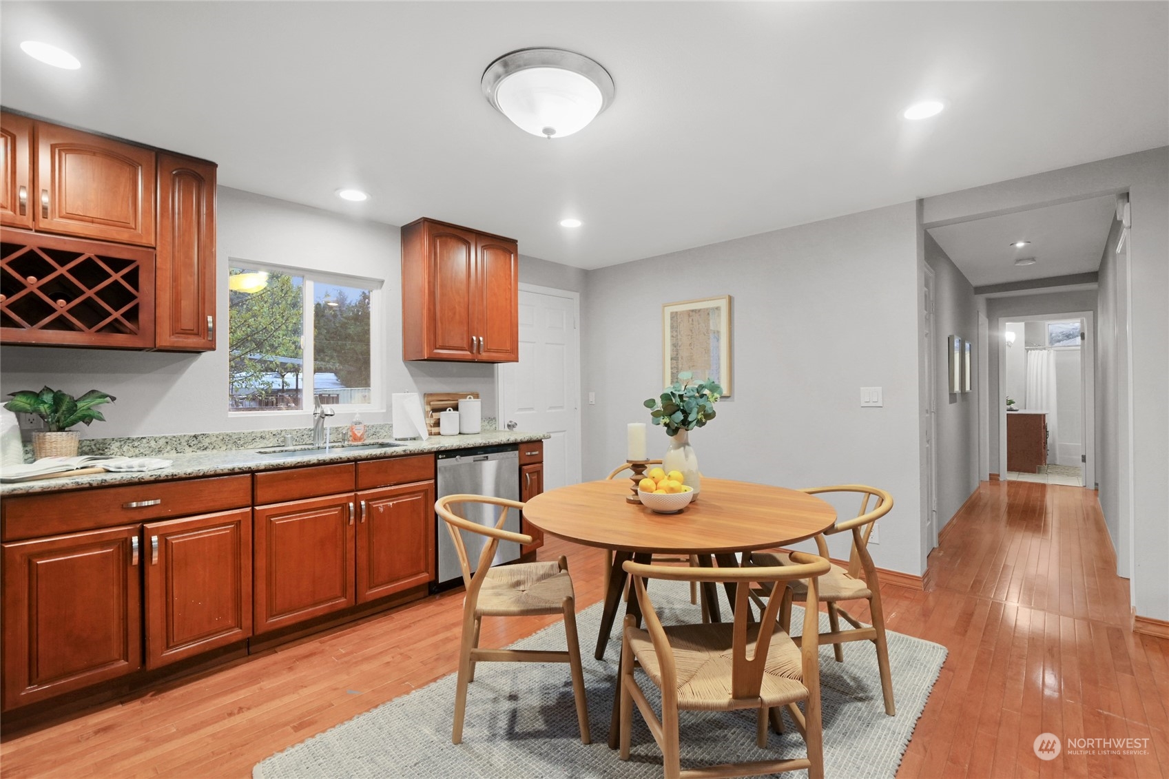 428 Southwest 124th Street Seattle, WA 98146 - Photo 10 of 28 a kitchen with stainless steel appliances granite countertop wooden floor dining table and chairs