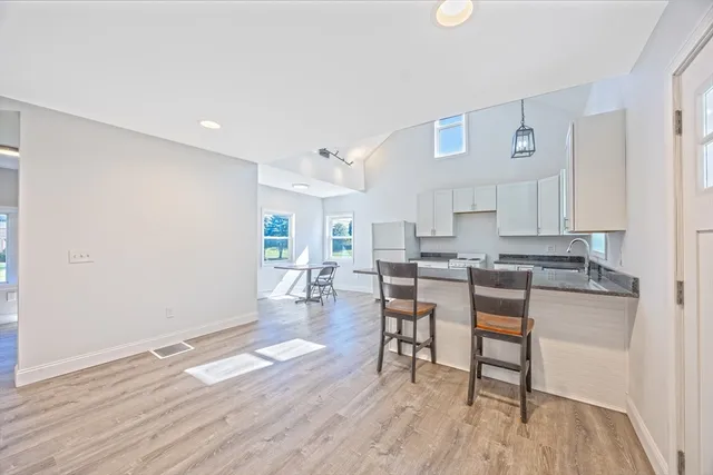 a living room with furniture a wooden floor and a sink