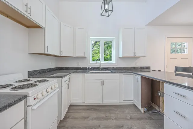 a kitchen with cabinets appliances a sink and a window
