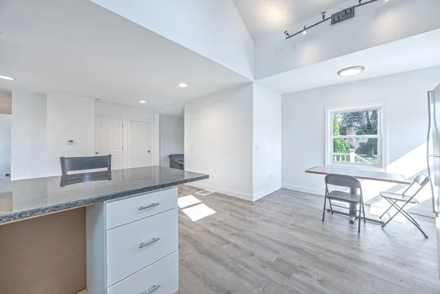 a kitchen with granite countertop a stove a sink and a wooden floors