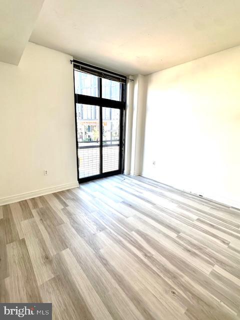 2120 Vermont Avenue Northwest, Unit 207 Washington, DC 20001 - Photo 12 of 32 an empty room with wooden floor and windows