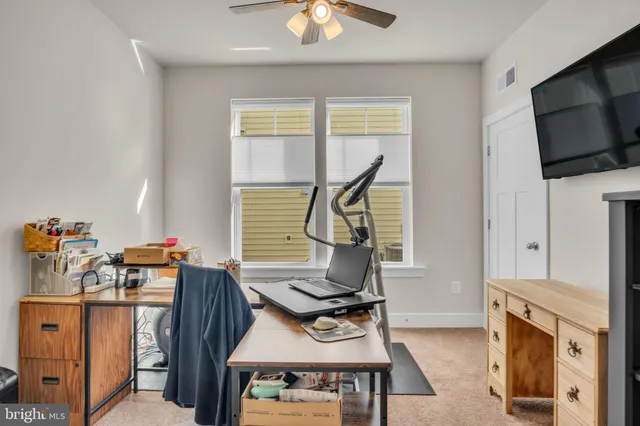 a view of a workspace with furniture and a window