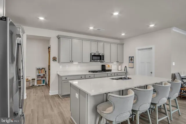 a kitchen with a dining table chairs and wooden floor