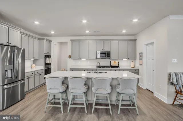 a kitchen with a dining table chairs refrigerator and cabinets