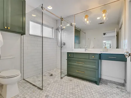a bathroom with a sink a toilet and shower