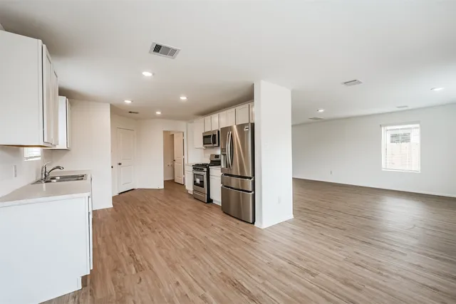 a kitchen with stainless steel appliances a refrigerator and a stove top oven
