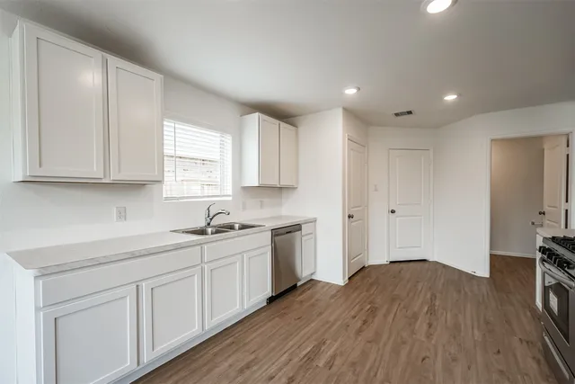 a kitchen with sink cabinets and wooden floor