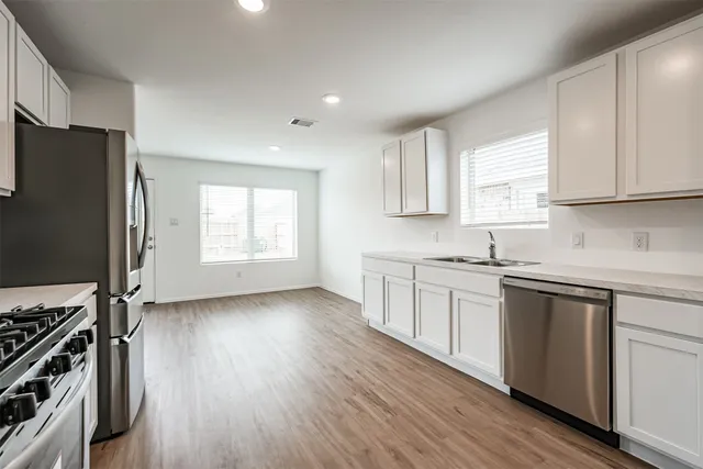 a kitchen with wooden floors and white appliances
